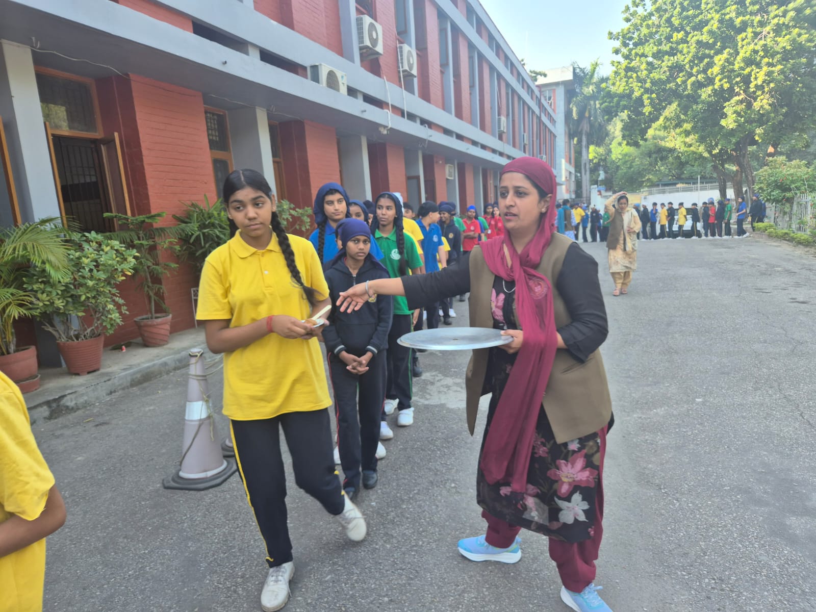 Staff distributing parshad to students